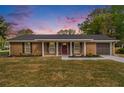 Charming brick home with a well-manicured lawn and inviting front entrance at sunset at 1857 Taffeta Trl, Lithonia, GA 30058