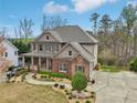 Charming two-story home with a covered porch, brick accents, and well-manicured landscaping at 1870 Marcia Overlook Dr, Cumming, GA 30041