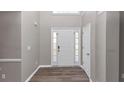 Welcoming entrance features a light gray wall, a white front door with glass panes, and wood-like floors at 7746 New Castle Way, Jonesboro, GA 30236