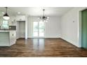 Open dining space with modern chandelier and hardwood floors, seamlessly connects to kitchen and patio at 1741 Hasty Rd, Marietta, GA 30062