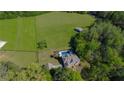 Aerial view of a private estate featuring a lush pasture and a large Gathering home with a pool at 20 Rivercreek Xing, Kingston, GA 30145