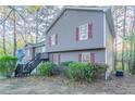 Split-level home featuring neutral siding, red shutters, and exterior staircase at 3094 Calumet Nw Cir, Kennesaw, GA 30152
