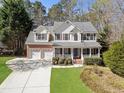 Beautiful two-story home with a well-kept lawn, two-car garage, and a cozy front porch with white columns at 3823 Briarstone Cv, Snellville, GA 30039