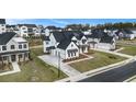 An aerial view of a neighborhood, showcasing a white brick home with a black roof and two-car garage at 7785 Wild Violet Dr, Cumming, GA 30040