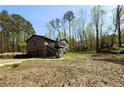 Two-story home with gray siding, a two-car garage, and a large yard surrounded by mature trees at 2919 Manitoba Ln, Marietta, GA 30062