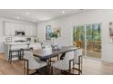 Open dining area with modern table and chairs, sliding doors to the back deck, and white cabinets at 59 Tallulah Trl, Sharpsburg, GA 30277