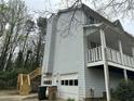 Rear exterior featuring a two-car garage and staircase at 4481 Dunmovin Nw Dr, Kennesaw, GA 30144