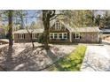 Charming two-story home featuring wood siding, black shutters, mature trees, and a small balcony at 53 Weatherstone Pkwy, Marietta, GA 30068