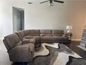 Spacious living room featuring a sectional sofa with cup holders, ceiling fan, and a neutral color scheme at 5915 Windsorcreek Dr, Douglasville, GA 30135
