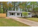 Well-maintained single-story house featuring a gray brick facade, a front lawn, and a long driveway at 1958 Calvary Hill Sw Ct, Marietta, GA 30008