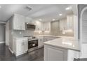 Bright kitchen features stainless steel appliances, grey backsplash, white cabinetry, and marble countertops at 2769 Peachtree Ne Rd # 10, Atlanta, GA 30305