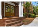 Charming front entrance with double wooden doors, brick steps, and classic architectural details at 3895 Overlake Dr, Cumming, GA 30041