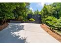 Long driveway leading to a modern black home surrounded by trees at 4 W Wesley Nw Rdg, Atlanta, GA 30327