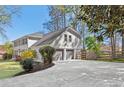 Side exterior view of the home with an attached two car garage and long driveway at 2480 Roxburgh Dr, Roswell, GA 30076