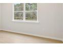Well-lit bedroom with neutral paint and wood-look flooring with large window view at 28 Kensington St, Kingston, GA 30145