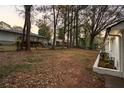 Spacious yard with mature trees bordering the freshly painted white brick home at 1970 Capri Dr, Decatur, GA 30032
