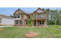 Attractive two-story home showcasing a well-maintained lawn and stylish brick exterior at 205 Haverling Pass, Hampton, GA 30228
