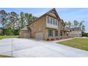Spacious home showcasing a convenient three-car garage and brick exterior at 205 Haverling Pass, Hampton, GA 30228