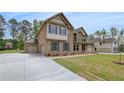 Wide concrete driveway leading to a three-car garage, enhancing the curb appeal of this brick-faced home at 205 Haverling Pass, Hampton, GA 30228
