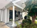 Inviting covered porch with seating area, stylish columns, and attractive landscaping at 1488 Cottage Way #32, Marietta, GA 30066