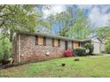Brick home with lush greenery, offering a blend of classic charm and natural beauty at 6884 Stephens Dr, Rex, GA 30273