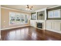 Bright living room featuring hardwood floors, a fireplace, and large windows providing ample natural light at 9942 Ashton Old Rd, Douglasville, GA 30135