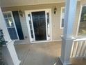 Inviting front porch featuring a black front door flanked by sidelights and sconce lighting at 2013 Reserve Pkwy, Mcdonough, GA 30253