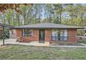 This single story brick home features large front windows, a covered parking area, and mature trees at 2875 Oldknow Nw Dr, Atlanta, GA 30318