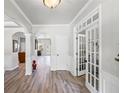Light and airy foyer with hardwood floors, white trim, and French doors leading to another room at 6597 River Island Dr, Buford, GA 30518