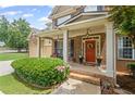 Inviting front porch with brickwork, white columns, and seasonal decorations at 6597 River Island Dr, Buford, GA 30518