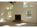 Inviting living room with a fireplace, ceiling fan, and large windows that bring in plenty of light at 4631 Calumet Cir, Duluth, GA 30096