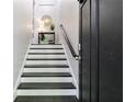 Elegant stairway featuring dark wood steps, white risers, and a modern black accent door at 482 Pearl Cove Ct, Atlanta, GA 30350
