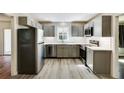 Modern kitchen featuring sleek gray cabinets, stainless steel appliances, quartz countertops, and stylish flooring at 1488 Drayton Woods Dr, Tucker, GA 30084