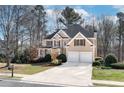 Beautiful two-story home with a manicured lawn and a two-car garage in a wooded neighborhood at 2405 Millwater Xing, Dacula, GA 30019