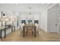 Formal dining room with a wooden table, seating for eight, contemporary chandelier, and hardwood floors at 1299 Sunland Ne Dr, Brookhaven, GA 30319