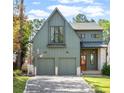 Charming two-story green home featuring a paved driveway, two-car garage, and a well-manicured lawn at 1299 Sunland Ne Dr, Brookhaven, GA 30319