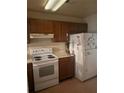 Standard kitchen featuring wooden cabinets, electric range, and refrigerator at 470 Teal Ct, Roswell, GA 30076