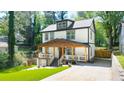 Inviting two-story home with a covered porch, wooden pillars, and a well-manicured lawn at 308 Reed St, Scottdale, GA 30079