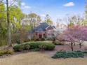 Charming brick home nestled in a lush, wooded landscape with flowering trees at 4231 Carrington Ct, Douglasville, GA 30135