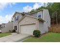 Charming two-story home with a manicured lawn and a two-car garage, set against a backdrop of lush greenery at 6407 Barker Station Walk, Sugar Hill, GA 30518