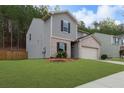Charming two-story home with a manicured lawn and a two-car garage, set against a backdrop of lush greenery at 6407 Barker Station Walk, Sugar Hill, GA 30518