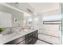 Elegant bathroom showcasing double sinks, a large mirror, and a luxurious glass-enclosed shower with marble tiles at 1611 Flat Shoals Rd, Atlanta, GA 30316