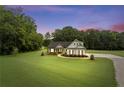 Exterior of a lovely home at dusk, surrounded by trees and lush green lawn at 340 Taylor Path, Dallas, GA 30157