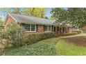 Well-maintained brick house featuring black shutters, green hedges, and a welcoming front porch at 5630 Lake Forrest Dr, Sandy Springs, GA 30342