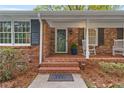 Inviting front porch with brick steps, rocking chairs, and a charming entrance at 5630 Lake Forrest Dr, Sandy Springs, GA 30342