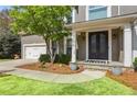 Close up of front door entrance with stone steps, landscaping and two car garage at 1165 Lea Dr, Roswell, GA 30076