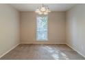 Bright dining room featuring neutral walls, carpet, and a modern chandelier over a sunlit window at 181 Bernice Dr, Lawrenceville, GA 30045