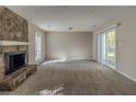 Spacious living room with a stone fireplace and sliding glass doors to the outdoor living area at 181 Bernice Dr, Lawrenceville, GA 30045