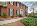 Charming brick home with manicured landscaping, featuring a paved walkway and inviting entrance with classic black shutters at 4292 Rocky Ne Gln, Roswell, GA 30075