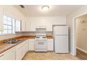 Bright kitchen featuring white appliances, laminate countertops and white cabinetry at 1803 Gingham Ct, Lithonia, GA 30058